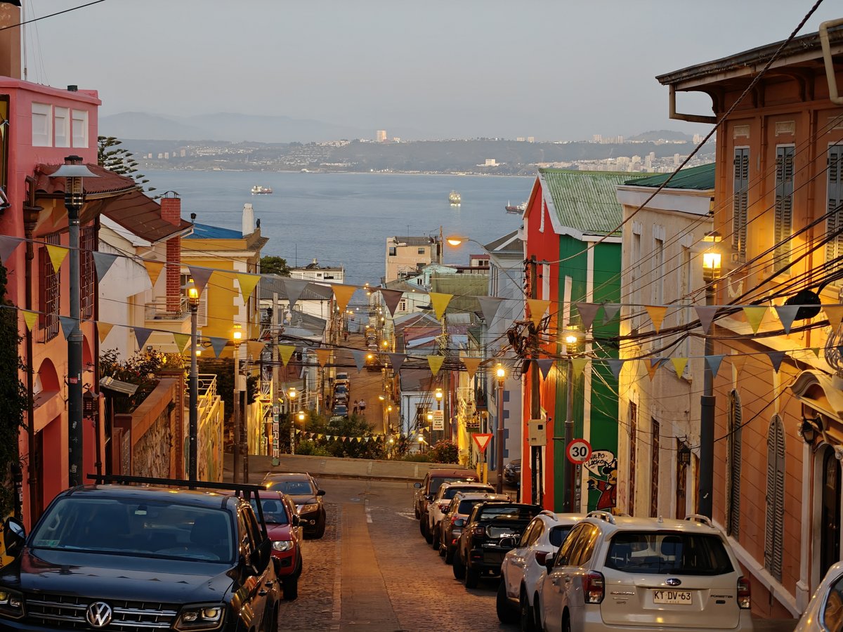Valparaiso hillside street at dusk with the bay in the distance
